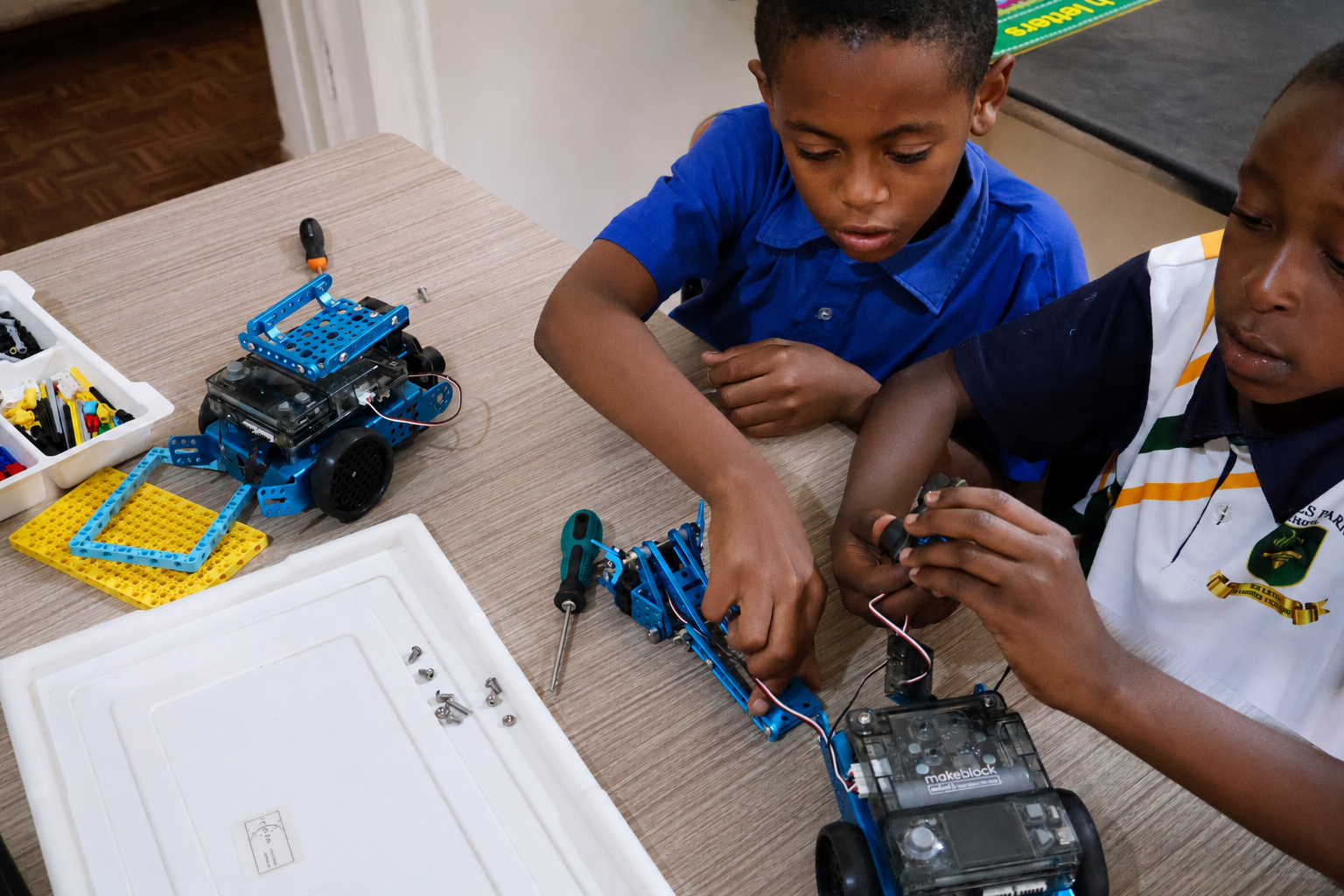 Two learners assembling a robot in the robotics club
